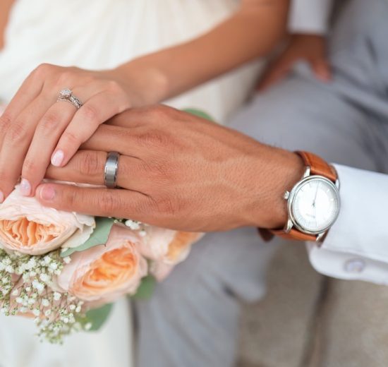 Couple wearing wedding band holding hands