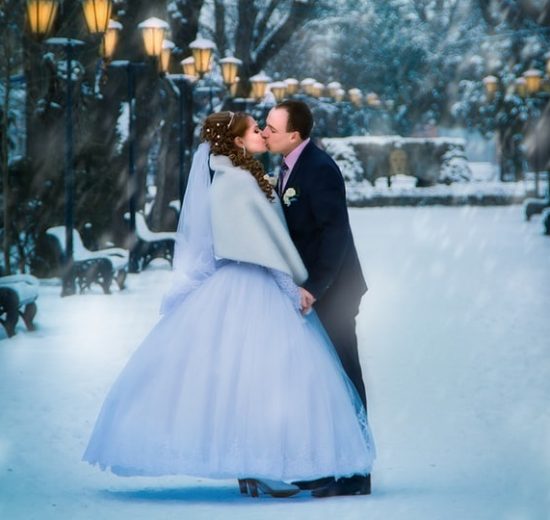 Couple kissing on the snow on wedding day