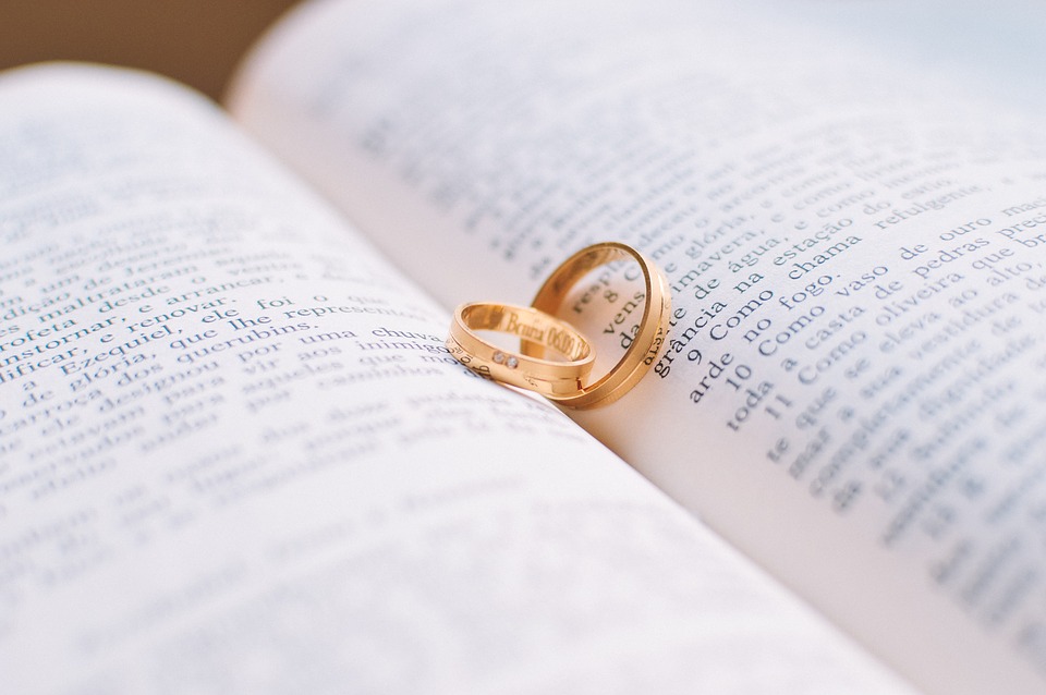 Yellow gold wedding band on pages of a open book