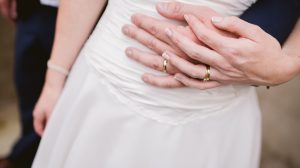 Couple wearing wedding ring holding hand
