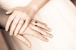 Bride and groom's hand wearing wedding ring