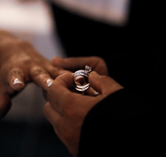 Man putting engagement ring on her girlfriend's finger