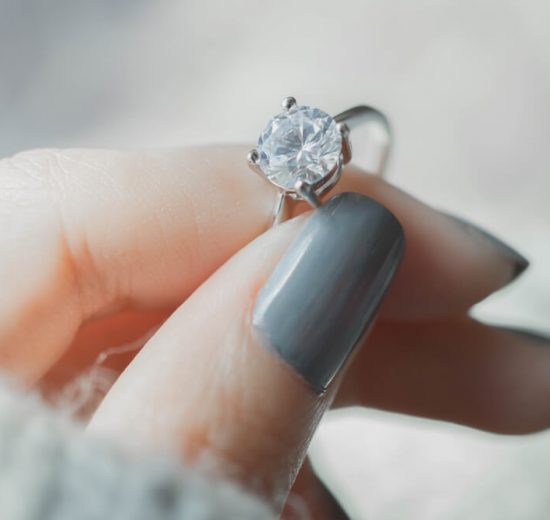 Woman holding moissanite engagement ring