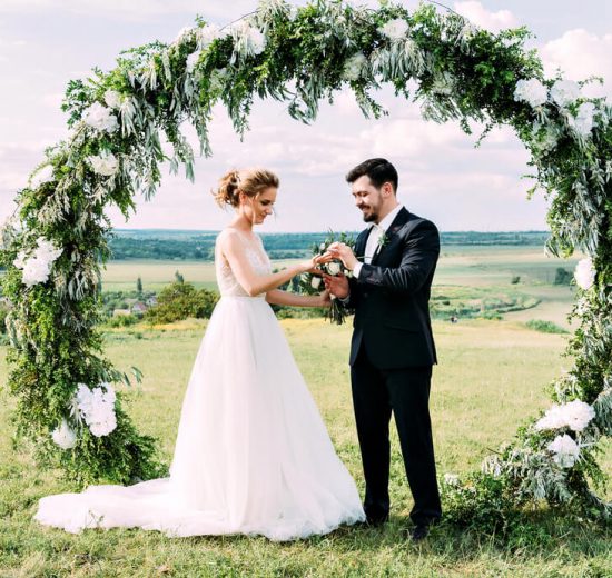 Bride and groom under wedding arch