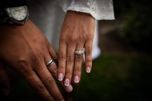 bride and grooms hands with white gold wedding rings close up