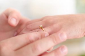 Woman wearing thin band engagement ring