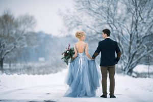 Bride wearing tulle dress holding groom's hand